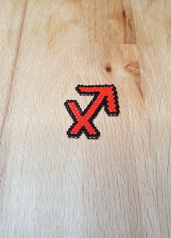 Bügelperlen Schütze-Symbol in Rot mit schwarzer Umrandung, auf Holz