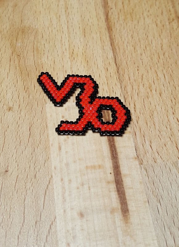 Rotes Bügelperlen‑Motiv der Zahl 30 mit schwarzer Umrandung auf hellem Holz