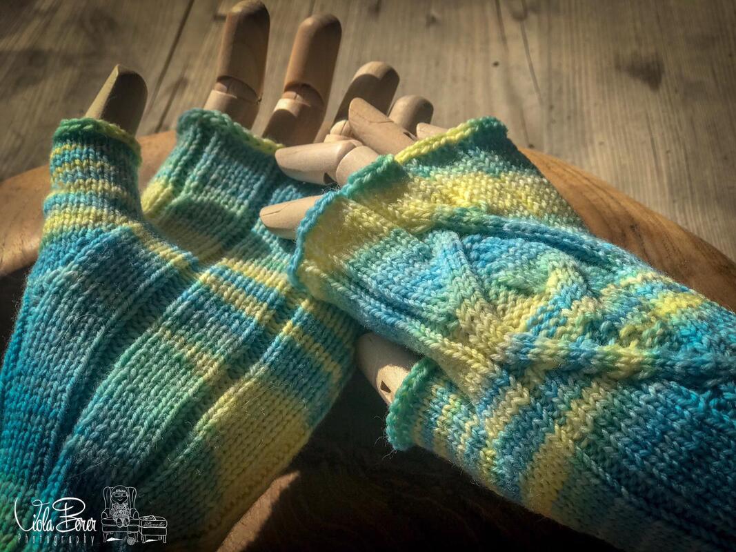 Gestrickte Armstulpe mit Zopfraute