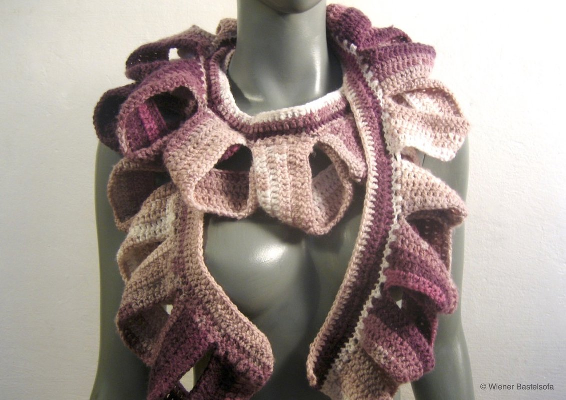 Gehäkelter Rüschenschal in Rosé- und Beigetönen an grauem Torso