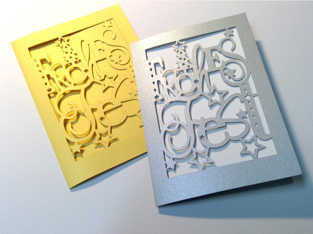 Goldene und silberne Weihnachtskarte mit ausgeschnittenem Schriftzug 'Frohes Fest', Weihnachtsbaum und Sternen