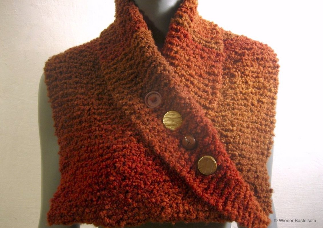 Rostroter gestrickter Kragenschal mit boucléähnlicher Struktur und vier Zierknöpfen auf einer Büste.