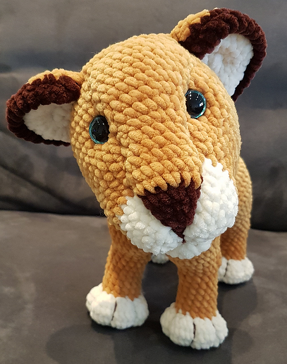 Gehäkeltes Löwenjunges Amigurumi in Hellbraun mit weißen Pfoten und dunkelbraunen Ohren, stehende Ansicht