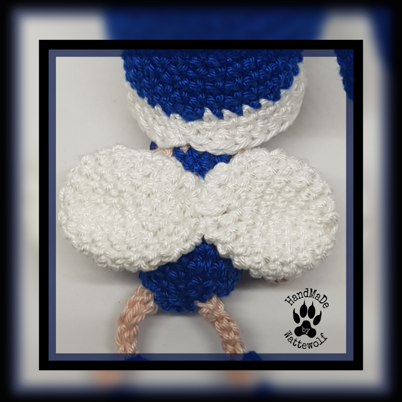 Nahaufnahme eines gehäkelten Objekts mit weißen Flügeln und blauem Körper