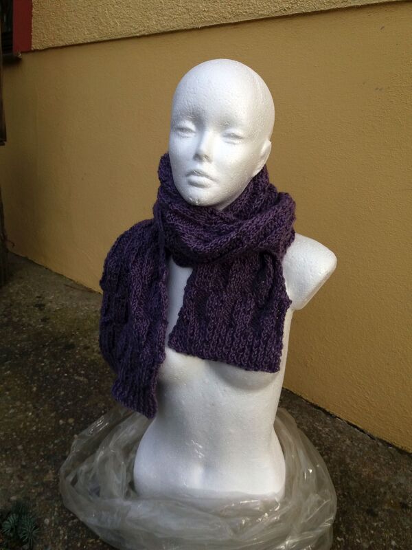 Schaufensterpuppe mit lila gestricktem Schal im Zopfmuster