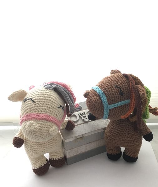 Seitenansicht von zwei gehäkelten Amigurumi-Pferden, Fokus auf Proportionen, Mähne und Zügel-Details