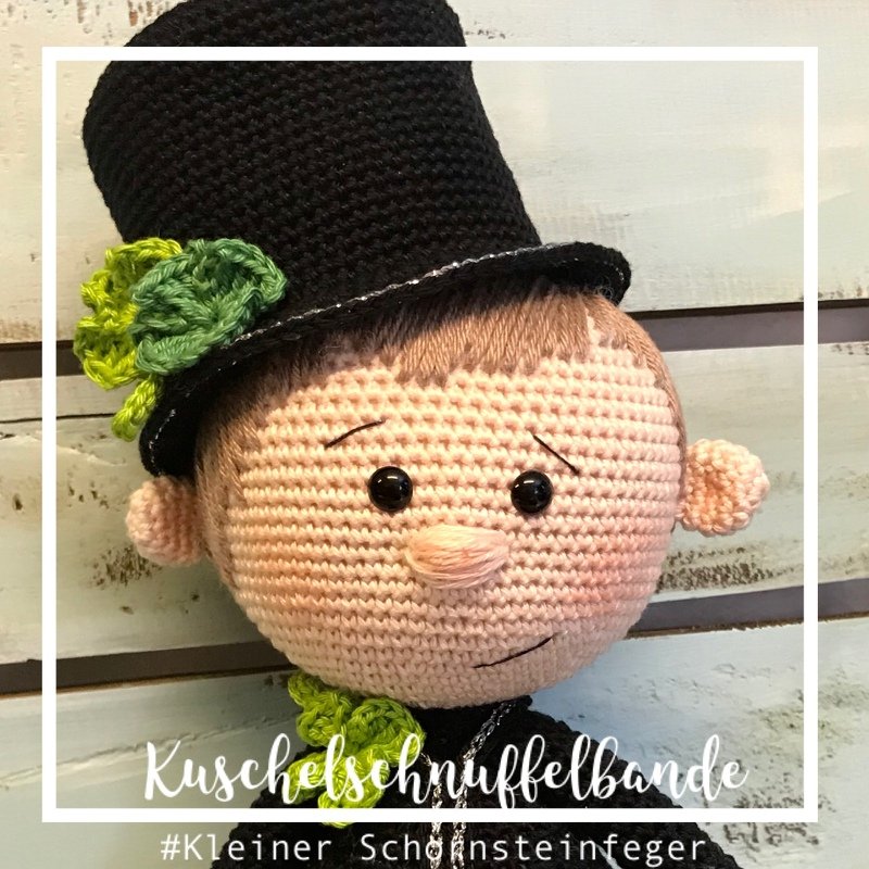 Gehäkelte Schornsteinfeger-Puppe mit schwarzem Zylinder, grünem Kleeblatt und schwarzen Sicherheitsaugen