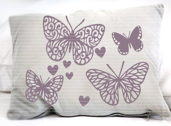 Vier violette Schmetterlingssilhouetten mit unterschiedlichen Mustern und mehrere kleine Herzen auf einem Kissen