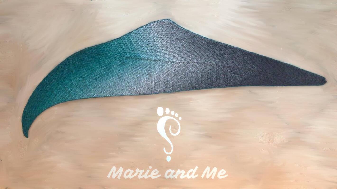 Gehäkeltes asymmetrisches Dreieckstuch in Türkis und Grau liegend