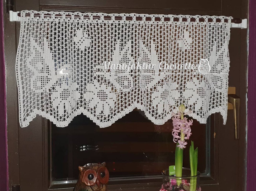Weiße gehäkelte Scheibengardine mit Filet-Häkelmuster und Zackenabschluss am Fenster