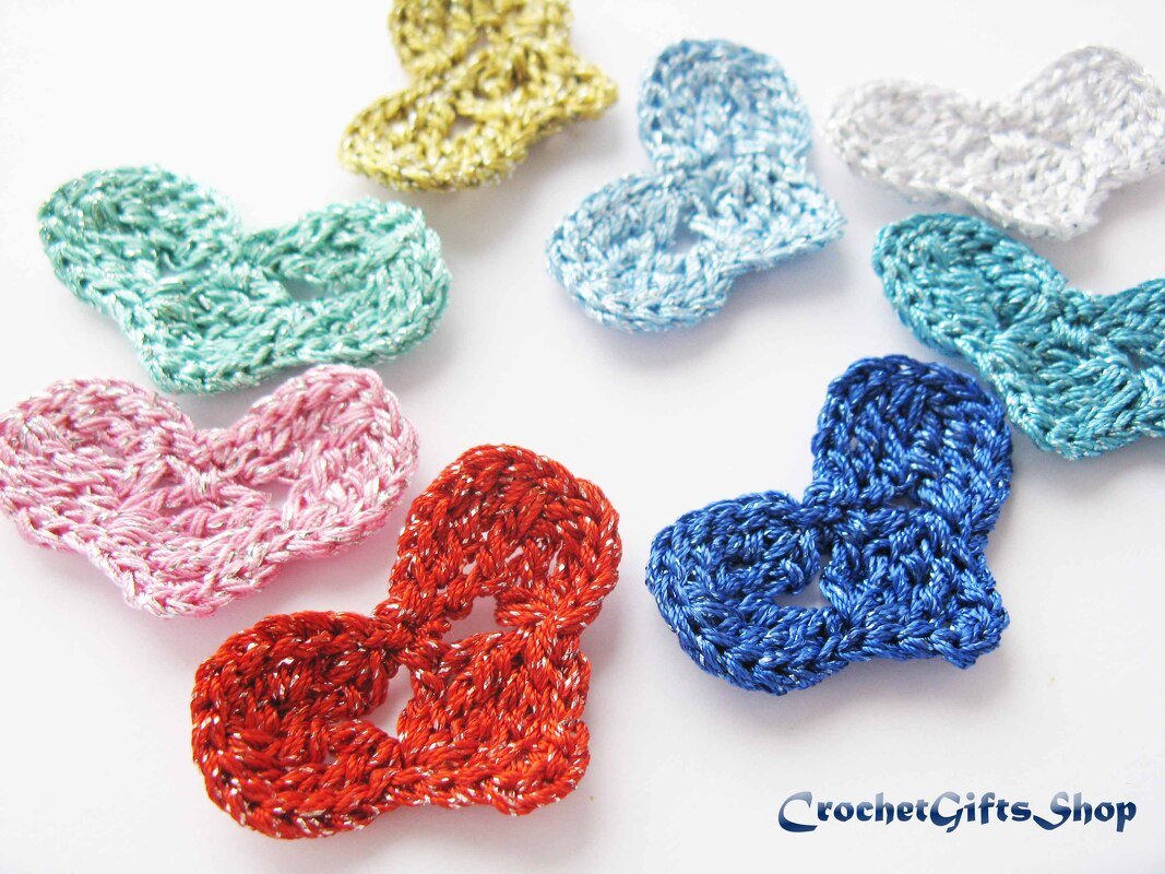 Small shimmery crocheted heart appliques in mixed colors on a white background
