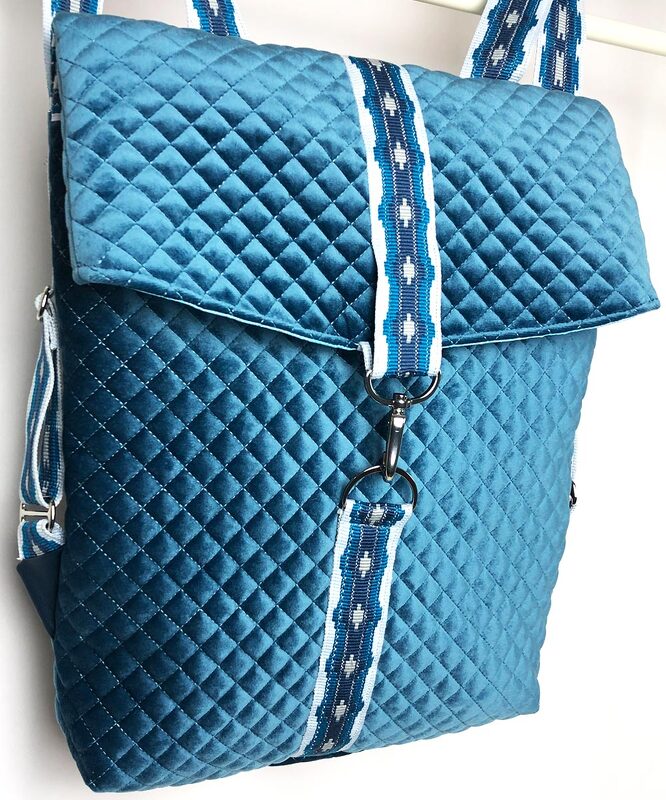 Gesteppter Rucksack aus türkisfarbenem Samt mit Überschlag und blau-weiß gemustertem Gurtband