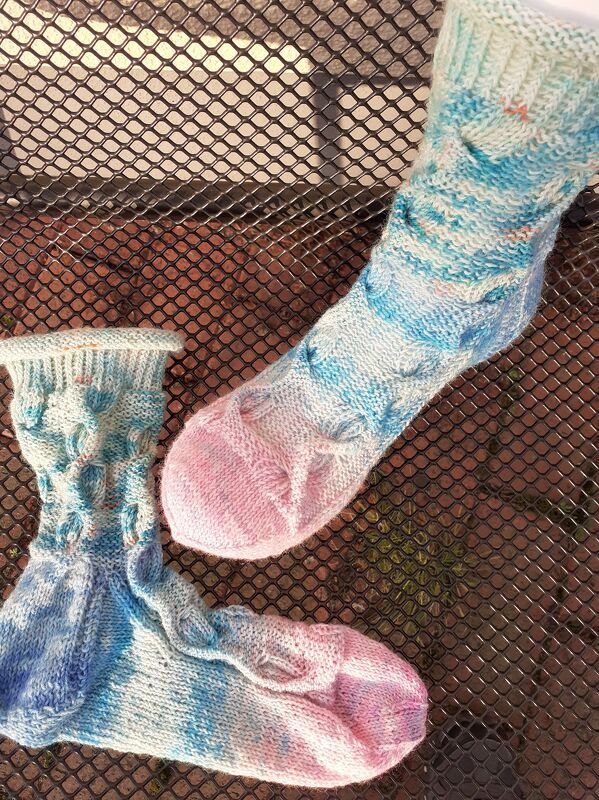 Pastellfarbene gestrickte Socken mit Zopf und Noppen