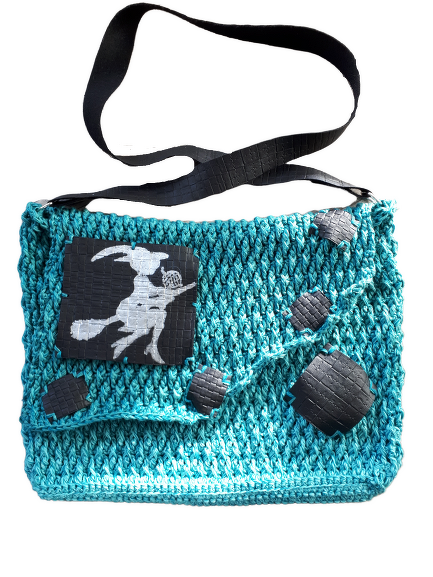 Gehäkelte türkise Umhängetasche mit schwarzem Patch, weißer Hexensilhouette und schwarzen Applikationen