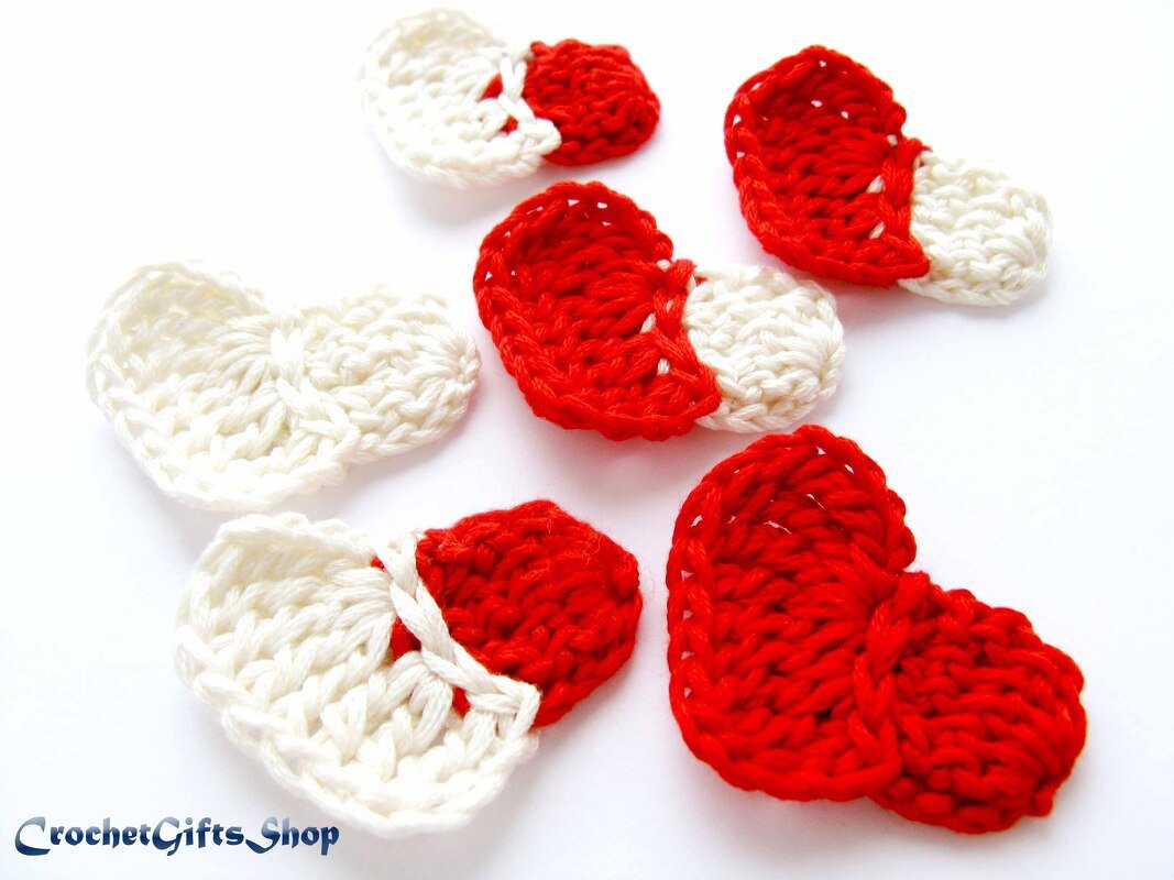 Red and white crocheted heart appliqués on white background