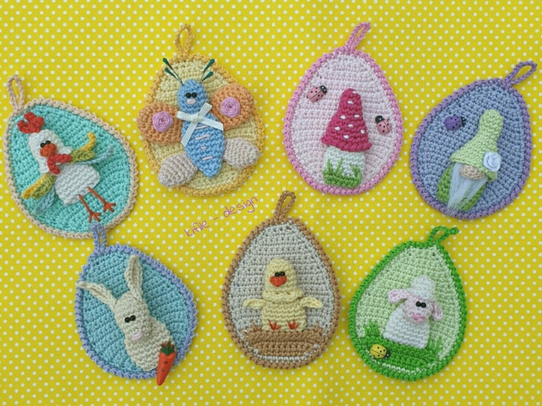 Sieben gehäkelte Ei-Applikationen mit Aufhängeschlaufen: Küken, Lamm, Hase, Huhn, Schmetterling, Pilz und Zwerg auf gelbem gepunktetem Hintergrund.