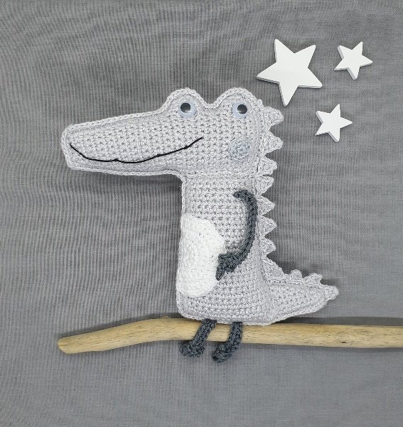 Einfaches gehäkeltes Amigurumi-Krokodil in Grau mit weißem Bauch und kleinen Rückenstacheln