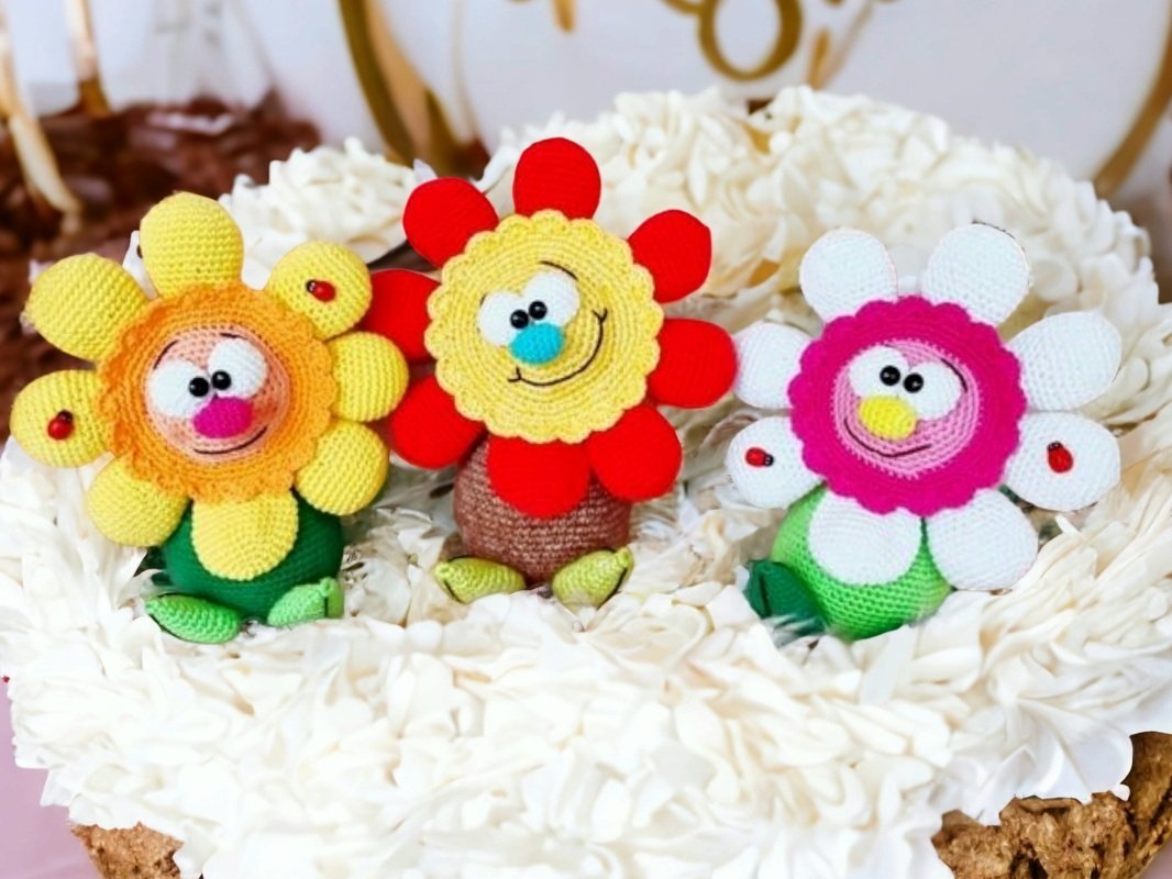 Three whimsical crocheted flowers with smiling faces suitable for Mother's Day or home decor