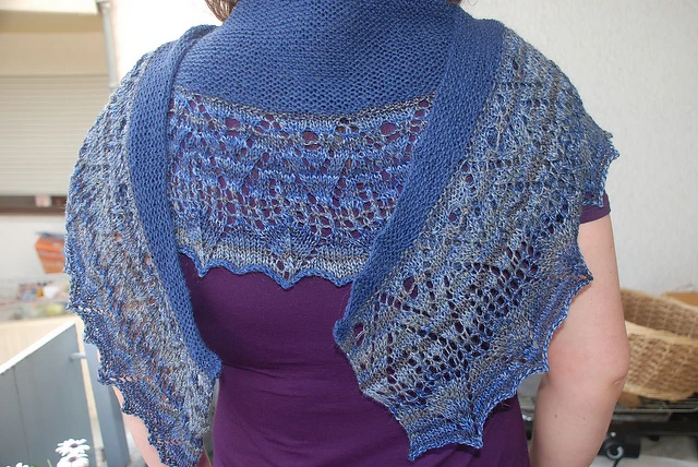 Rückenansicht: blauer, gestrickter Schal mit Loch- und Spitzenmuster.