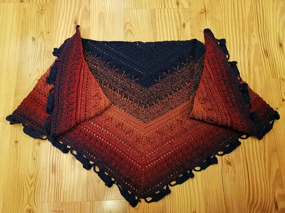 Gehäkeltes Dreieckstuch mit Farbverlauf von Dunkelblau zu Rostrot auf Holzboden