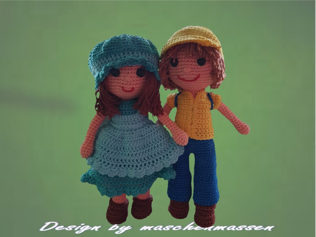 Zwei gehäkelte Amigurumi-Puppen, Mädchen in blaugrünem Kleid und Junge in gelb-blauer Kleidung.