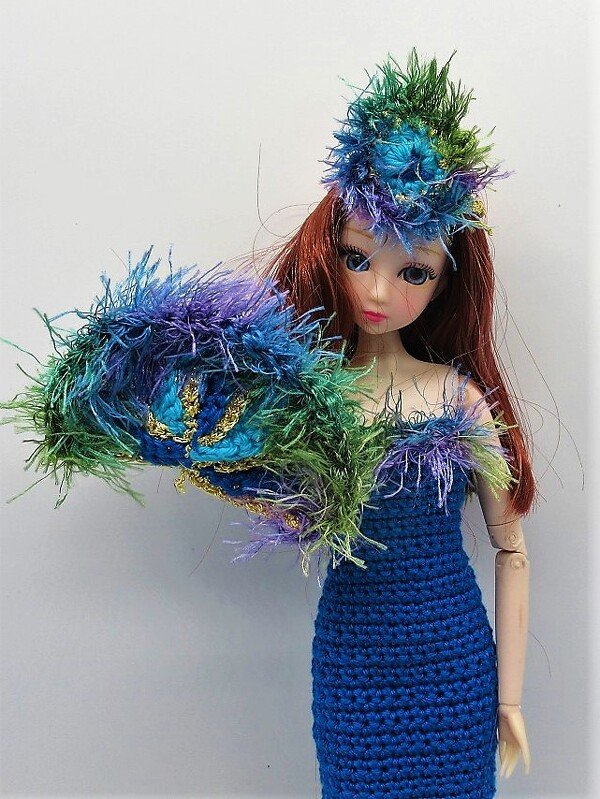 Puppe mit gehäkeltem königsblauen Kleid und buntem flauschigem Faschingshut