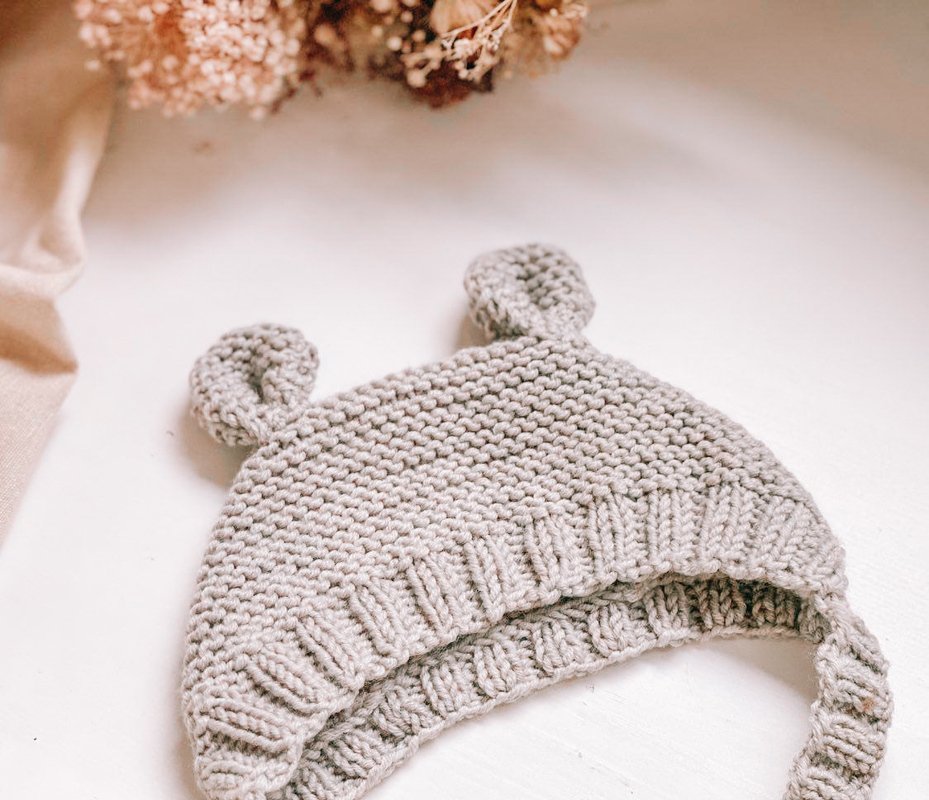Gestrickte Baby-Öhrchen-Mütze in Grau, kraus rechts mit Rippenbündchen und Bindebändern