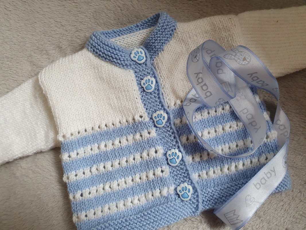 Hellblau-weiß gestrickte Babyjacke mit Pfotenknöpfen und Zierband