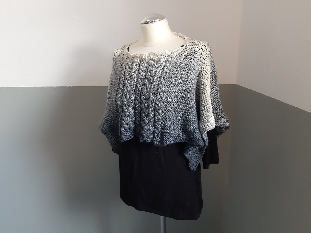 Gestrickter Poncho mit Zopfmuster und Grauverlauf auf Mannequin