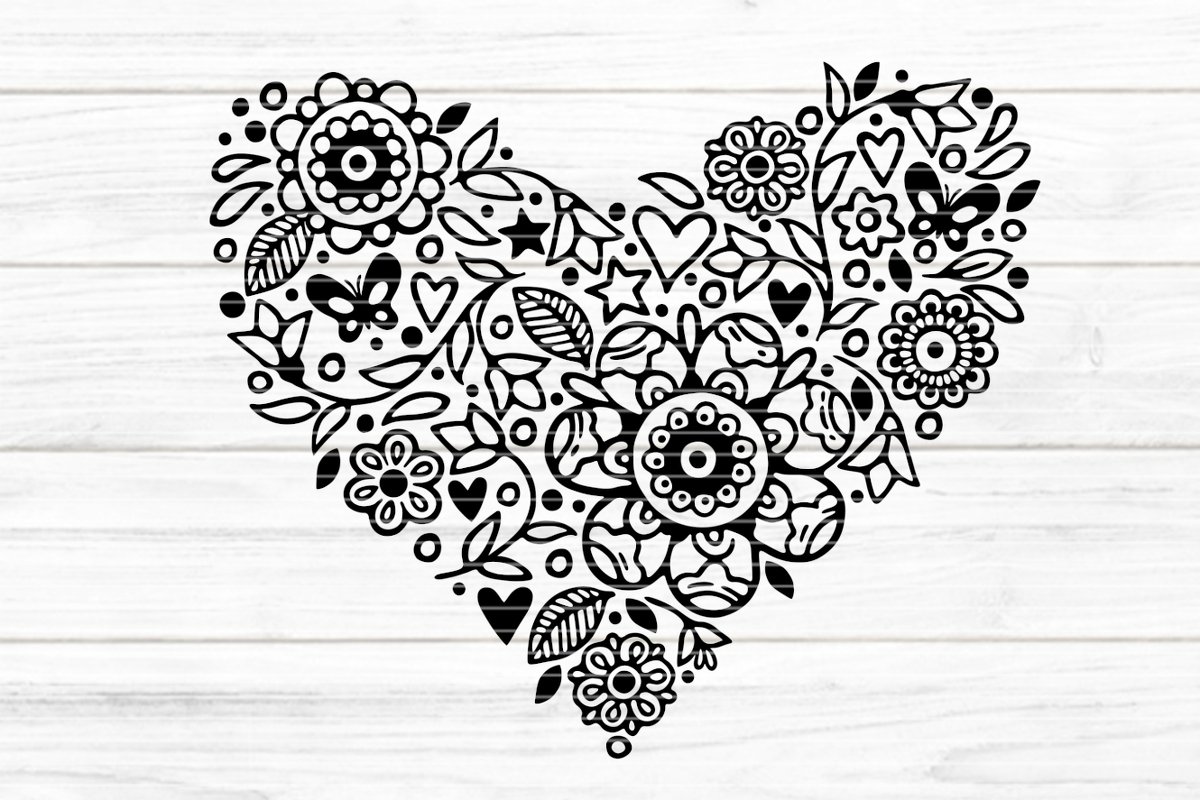 Schwarz-weißes Herz aus filigranen Blumen, Blättern und Schmetterlingen auf hellem Holzuntergrund.