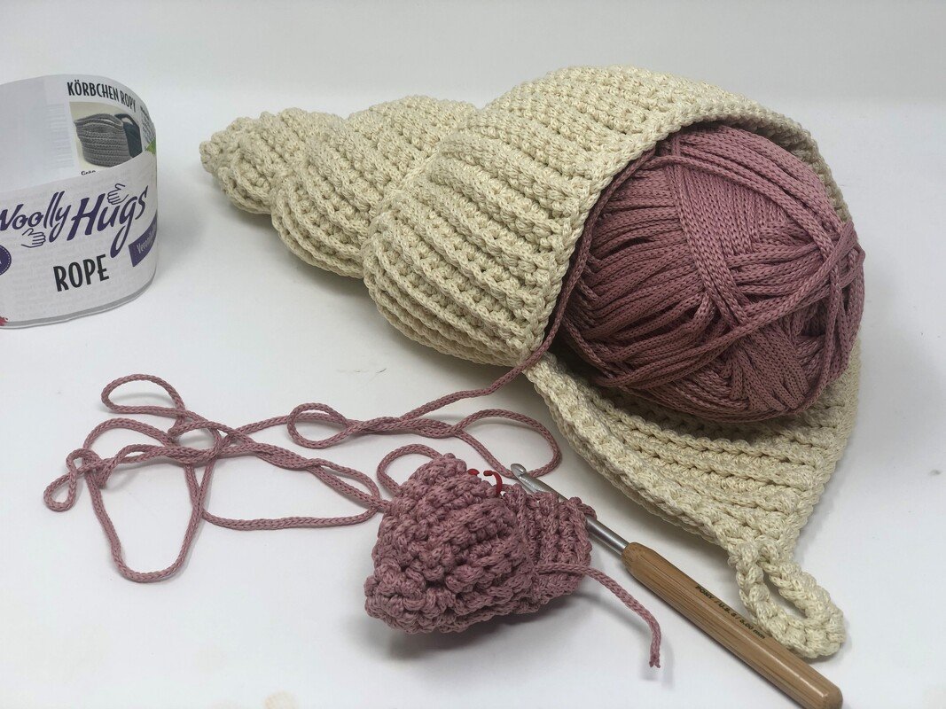 Nahaufnahme gehäkeltes Utensilo aus dickem Garn mit Häkelnadel