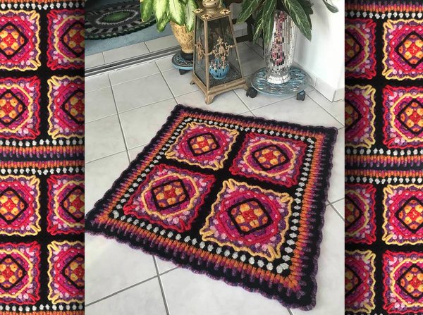 Quadratischer gehäkelter Teppich aus vier bunten Granny‑Squares auf hellem Fliesenboden