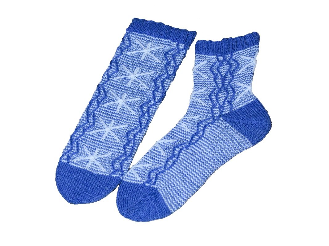 Blau gestricktes Sockenpaar mit Stern- und Wellenmuster auf weißem Hintergrund, eine Socke flach, die andere geformt.