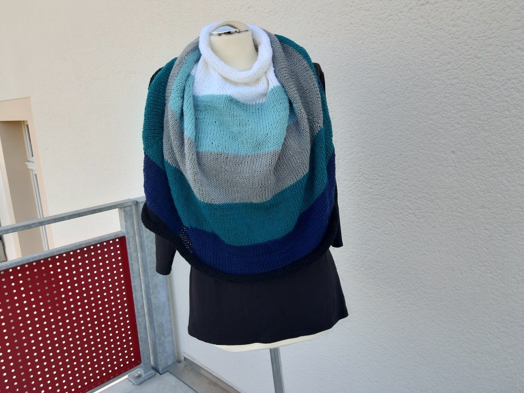 Halbrundes gestricktes Tuch mit gestuften Blau- und Grautönen auf Schaufensterpuppe