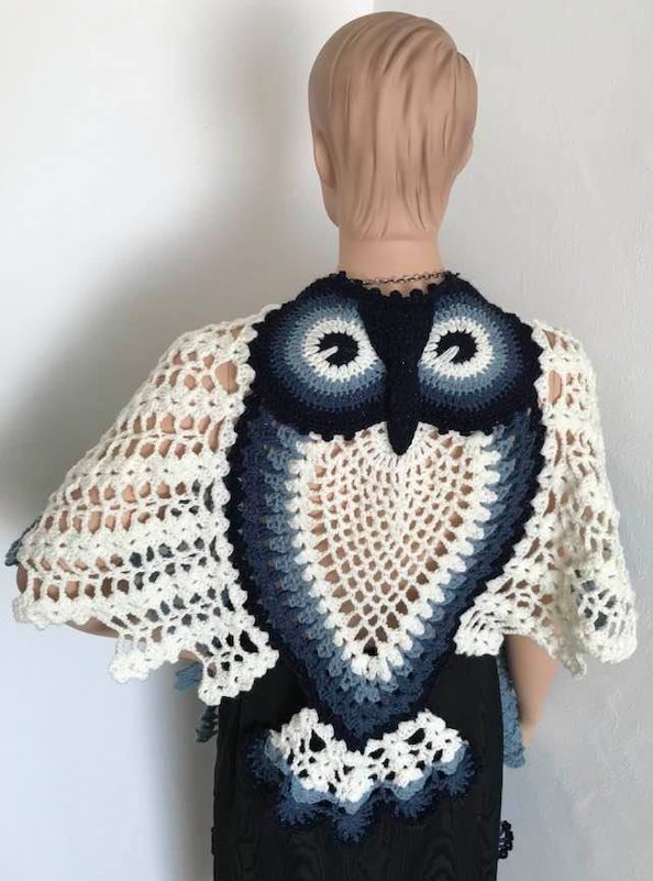 Back view of a blue and white crocheted owl shawl on a mannequin.