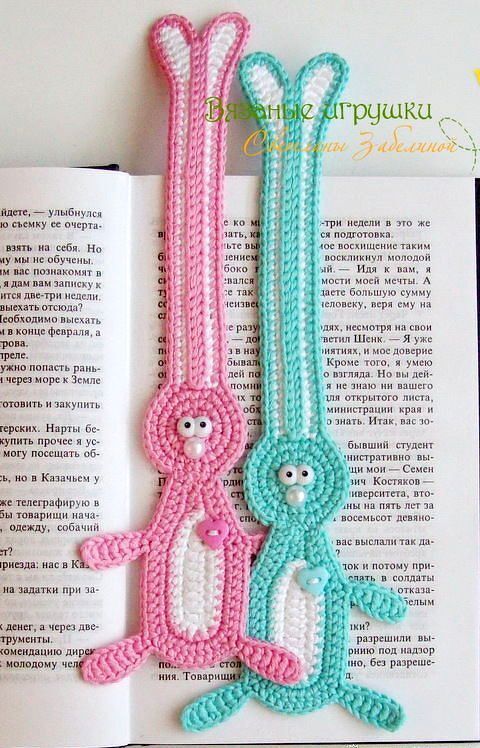 Zwei gehäkelte Hasen-Lesezeichen (rosa und türkis) in einem aufgeschlagenen Buch