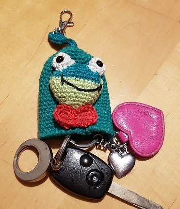 Gehäkeltes Frosch-Schlüsseletui mit roter Fliege an einem Schlüsselbund
