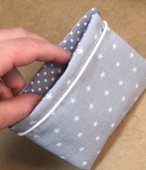 Kleines pastellblaues Etui mit weißen Sternen und grauem Innenfutter mit Punkten, weiße Paspel sichtbar