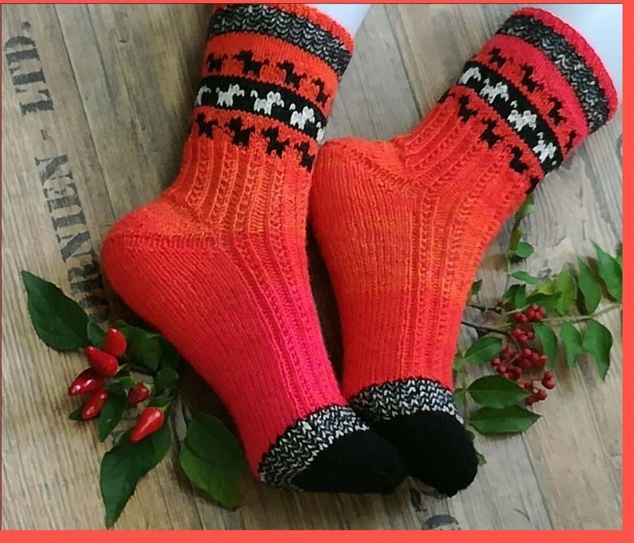 Orangene gestrickte Socken mit schwarzer Spitze und gemustertem Bündchen