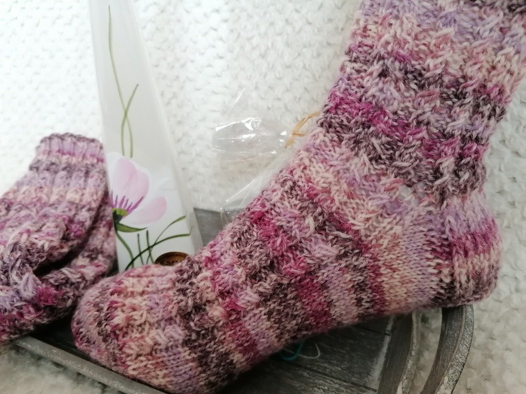 Nahaufnahme einer gestrickten Damensocke mit Bündchen, Ferse und mehrfarbigem Farbverlauf
