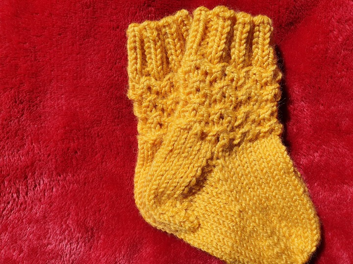 Strickanleitung für Babysöckchen mit Pfauenmuster Größe 62/68