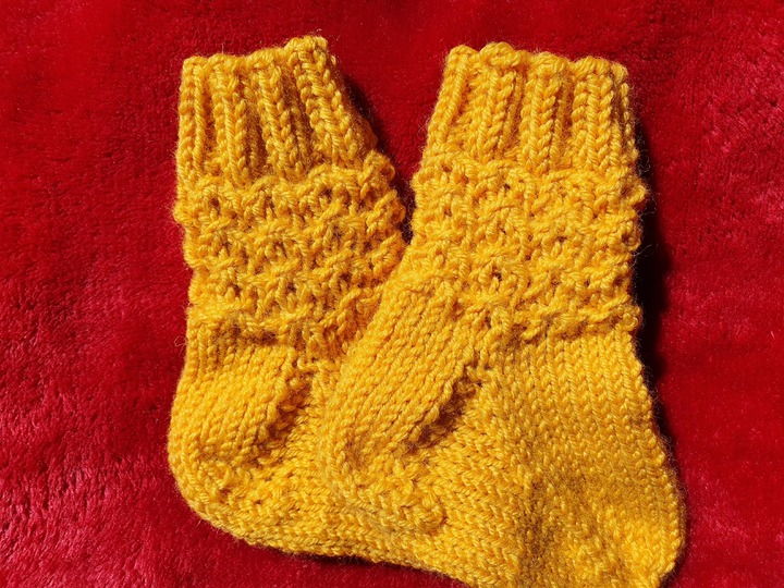 Strickanleitung für Babysöckchen mit Pfauenmuster Größe 62/68