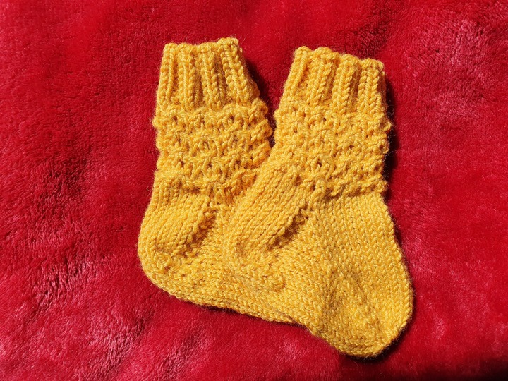 Strickanleitung für Babysöckchen mit Pfauenmuster Größe 62/68