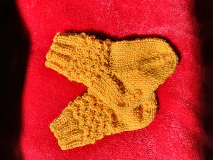 Strickanleitung für Babysöckchen mit Pfauenmuster Größe 62/68