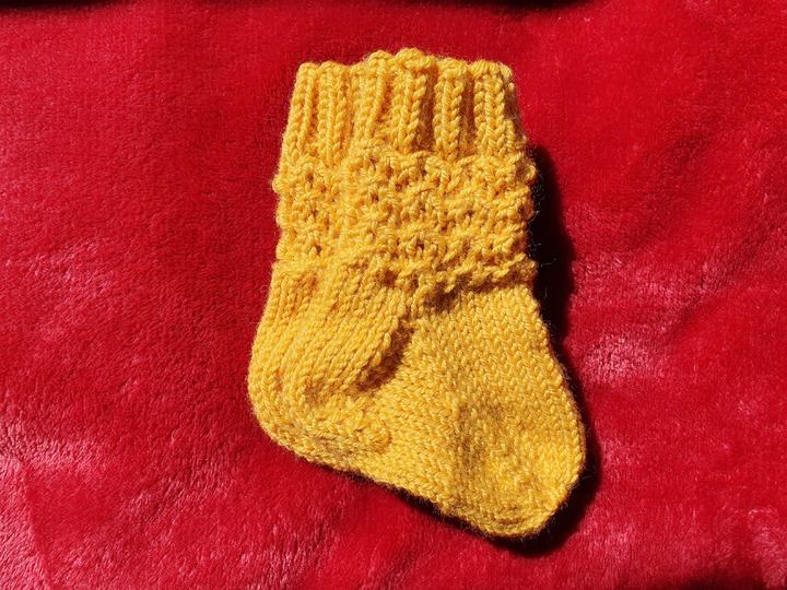 Strickanleitung für Babysöckchen mit Pfauenmuster Größe 62/68