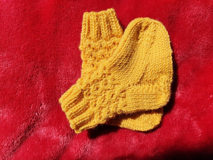 Strickanleitung für Babysöckchen mit Pfauenmuster Größe 62/68