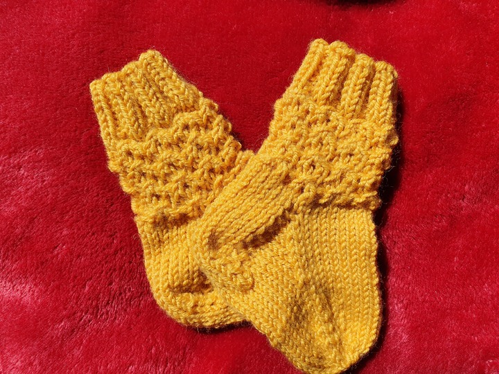 Strickanleitung für Babysöckchen mit Pfauenmuster Größe 62/68