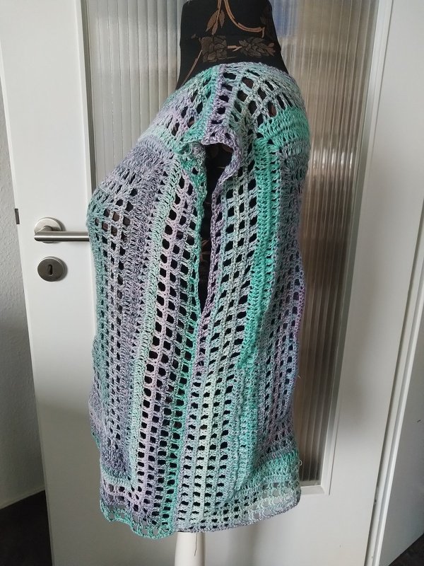 Seitenansicht einer gehäkelten Tunika im Ajourmuster in Mint und Lila auf einer Schneiderpuppe