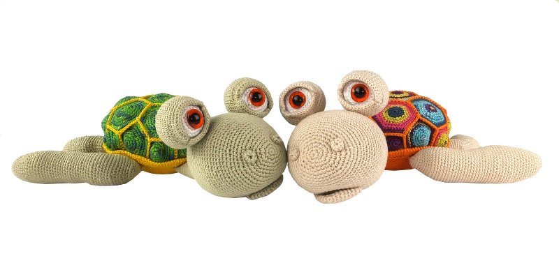 Zwei gehäkelte Amigurumi-Schildkröten mit bunten Panzer-Mustern und großen Augen