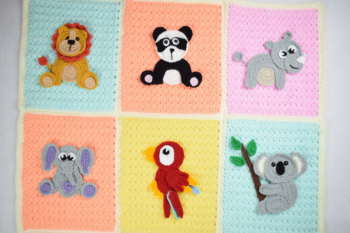 Rectangular crocheted baby blanket in a 3x2 grid of pastel squares with appliquéd lion, panda, rhino, elephant, parrot and koala